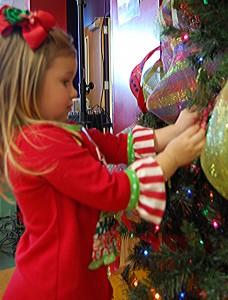 Three-year-old Graci Holder, from Hixson, Tenn., hangs an ornament on the tree.  Graci is a sibling of a patient at Children’s Hospital. 